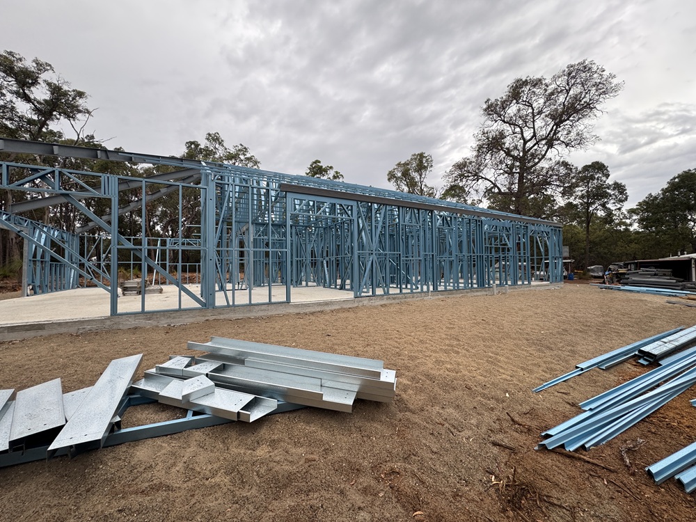 Steel wall frames and trusses on a house build under an overcast sky